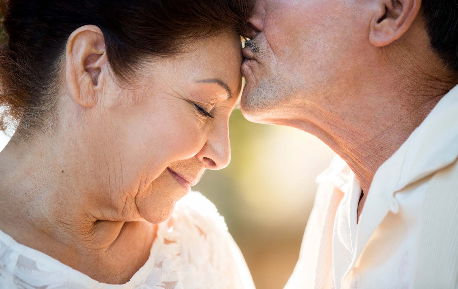 Man kisses a woman on the forehead