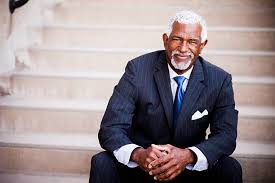 Elderly man in a suit sitting on stairs